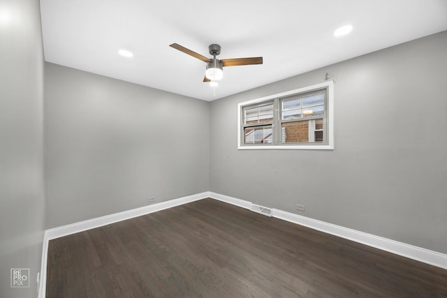 spare room with dark hardwood / wood-style floors and ceiling fan