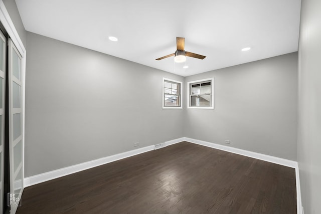 spare room featuring dark wood-type flooring and ceiling fan