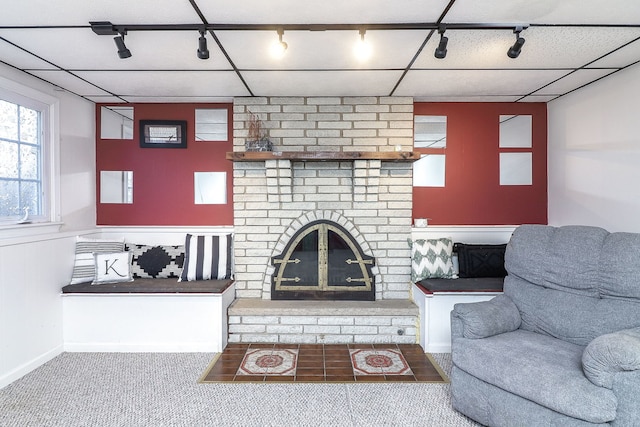 living room featuring track lighting, carpet flooring, and a fireplace