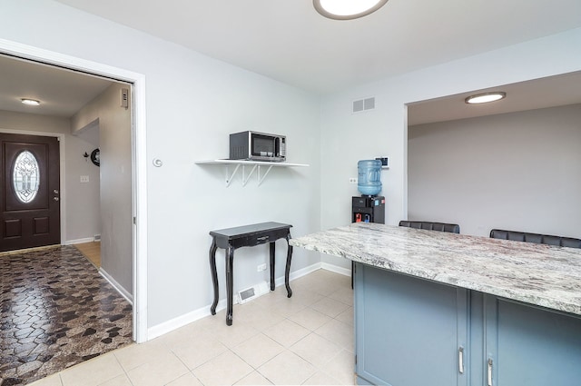 interior space featuring blue cabinets and light tile patterned flooring