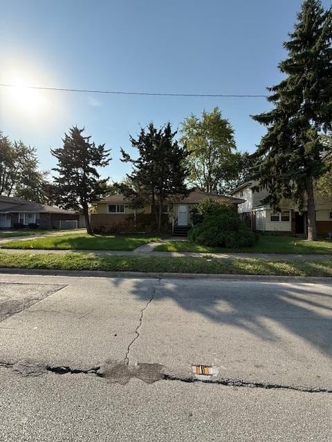 view of property hidden behind natural elements featuring a front yard