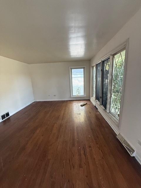 unfurnished room with dark wood-type flooring