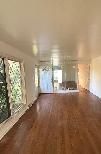 unfurnished living room with dark wood-type flooring