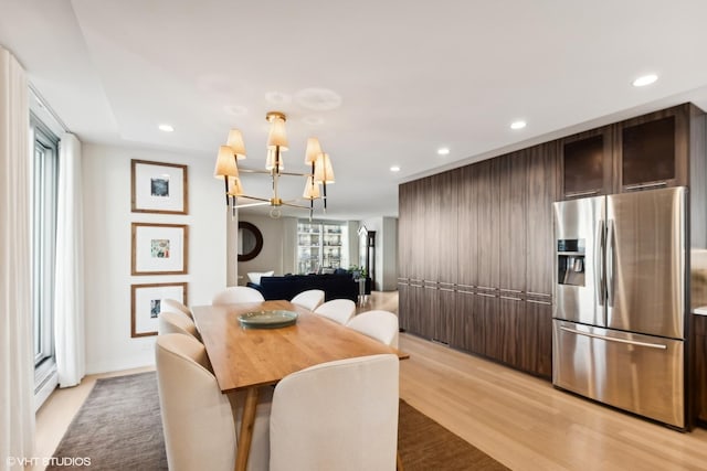 dining space featuring an inviting chandelier and light hardwood / wood-style flooring