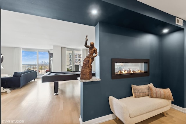 playroom with a multi sided fireplace, wood-type flooring, and billiards