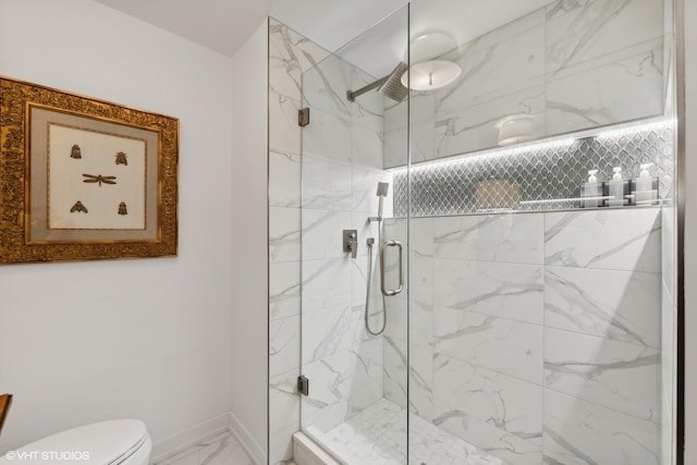 bathroom featuring toilet and a shower with shower door