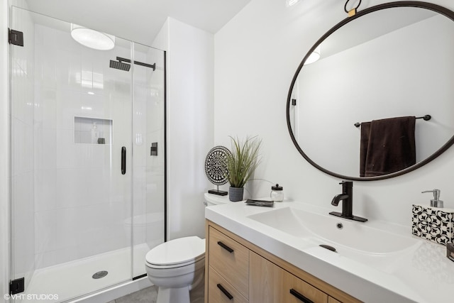 bathroom with vanity, a shower with shower door, and toilet