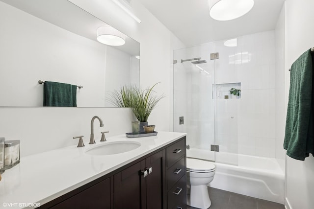 full bathroom featuring tile patterned flooring, vanity, combined bath / shower with glass door, and toilet