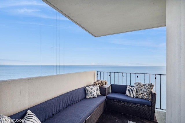 balcony with an outdoor living space and a water view