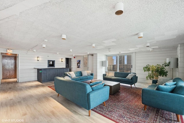 living room featuring a textured ceiling and light hardwood / wood-style floors