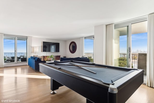 game room featuring expansive windows, pool table, light hardwood / wood-style flooring, and a wealth of natural light