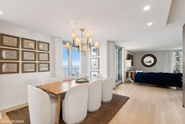 dining room featuring a notable chandelier and light wood-type flooring