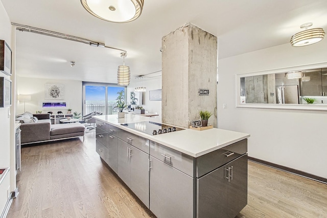 kitchen with black electric cooktop, a center island, light hardwood / wood-style floors, and hanging light fixtures