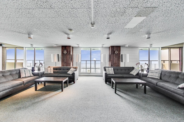 living room with floor to ceiling windows, a textured ceiling, and carpet