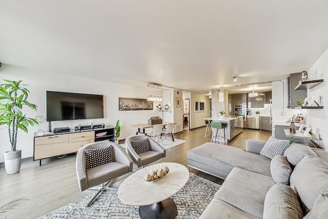 living room with light hardwood / wood-style flooring and a notable chandelier