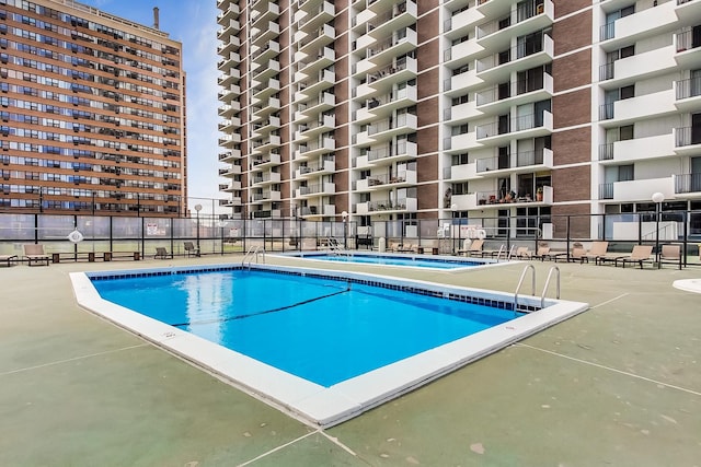 view of swimming pool with a community hot tub and a patio