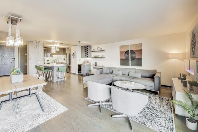 living room with beverage cooler and light wood-type flooring