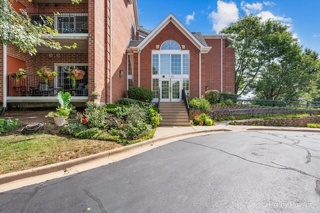 property entrance featuring brick siding and fence