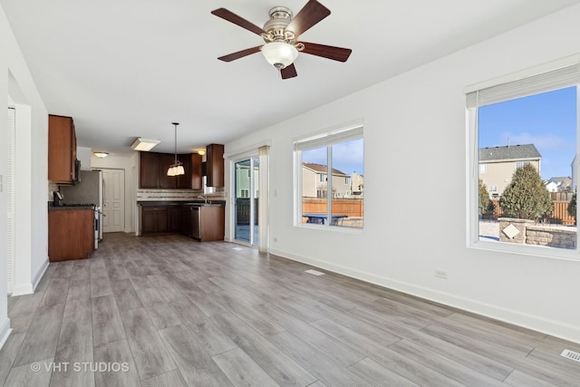 unfurnished living room featuring ceiling fan, sink, and light hardwood / wood-style floors