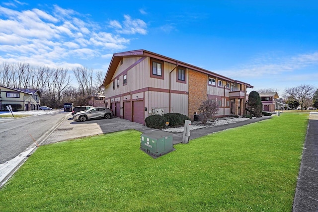 exterior space with a garage and a lawn