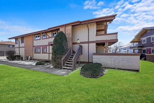 rear view of property with a yard and central AC