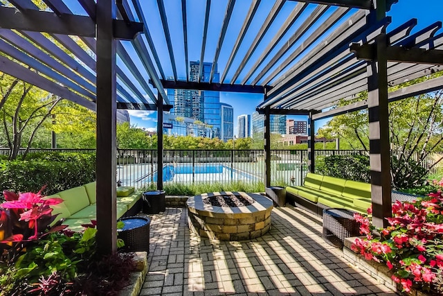 view of patio / terrace with an outdoor living space with a fire pit, a fenced in pool, and a pergola