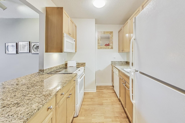 kitchen featuring light stone countertops, white appliances, light brown cabinets, and light wood-type flooring