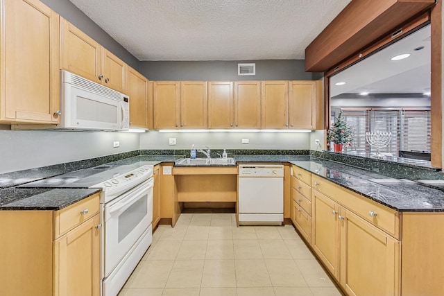 kitchen with sink, dark stone counters, white appliances, and light brown cabinetry