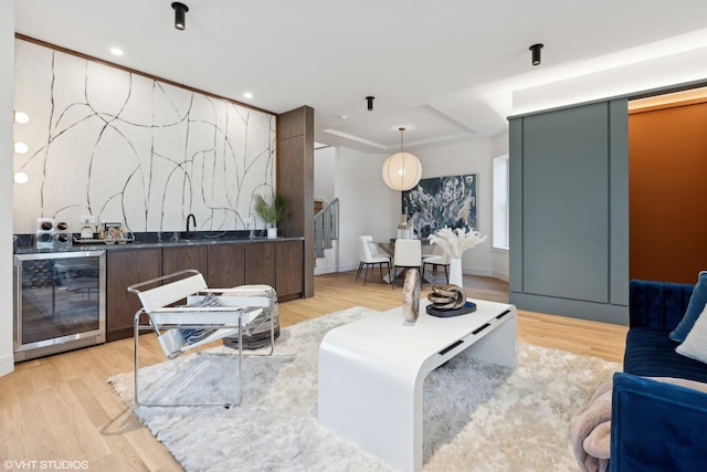 living room featuring light wood-type flooring, indoor wet bar, and wine cooler