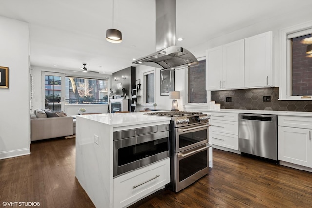 kitchen featuring white cabinets, stainless steel appliances, hanging light fixtures, and island range hood