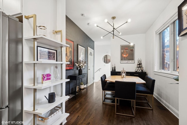 dining area with dark wood-type flooring and a notable chandelier