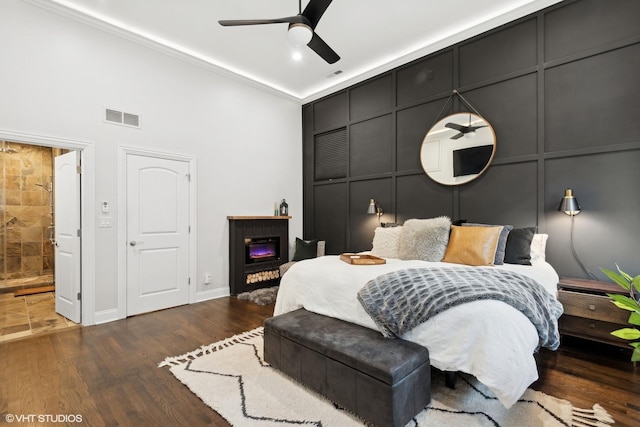 bedroom with dark hardwood / wood-style flooring, ensuite bath, and ceiling fan