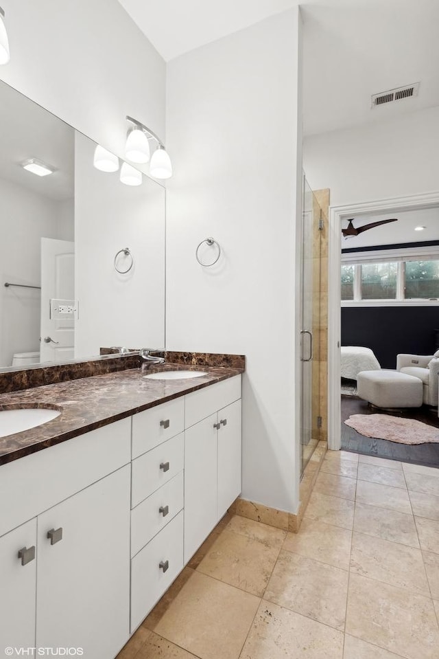 bathroom featuring tile patterned flooring, vanity, and a shower with shower door