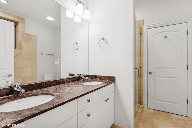 bathroom featuring walk in shower, vanity, tile patterned floors, and toilet