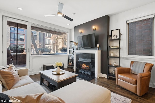 living room with dark hardwood / wood-style flooring, a fireplace, and ceiling fan