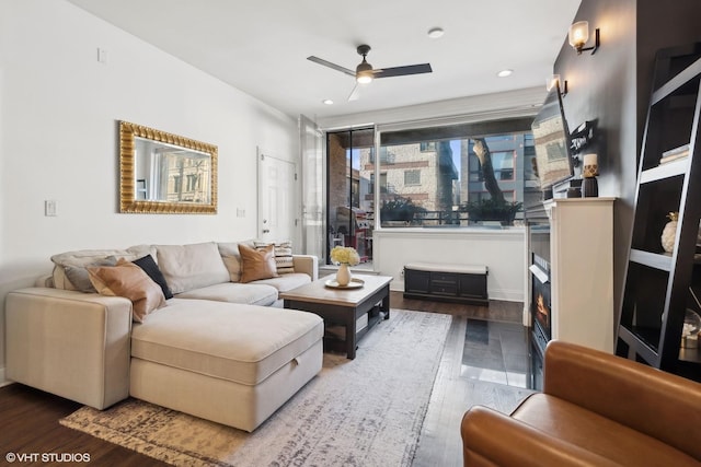 living room featuring ceiling fan and dark hardwood / wood-style flooring