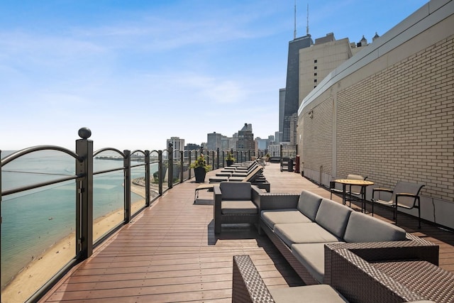 exterior space featuring a view of the beach, outdoor lounge area, and a water view