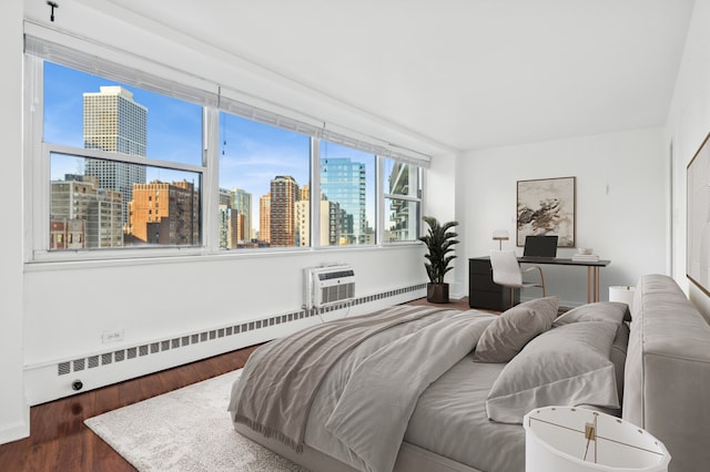 bedroom featuring a wall mounted air conditioner, dark hardwood / wood-style flooring, and a baseboard heating unit