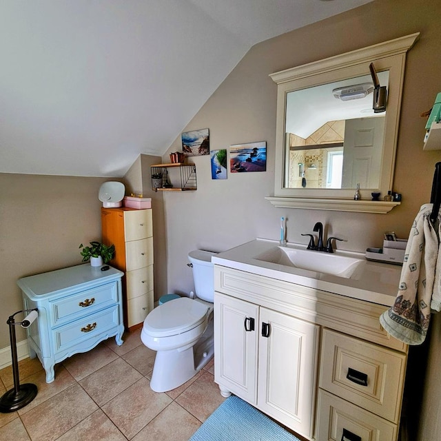 bathroom with tile patterned floors, toilet, vanity, and vaulted ceiling