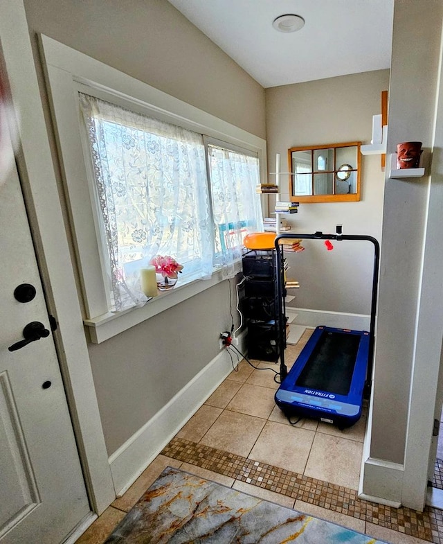 exercise room with light tile patterned flooring