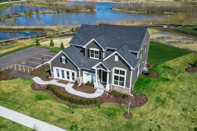 view of front facade with a water view and a front lawn