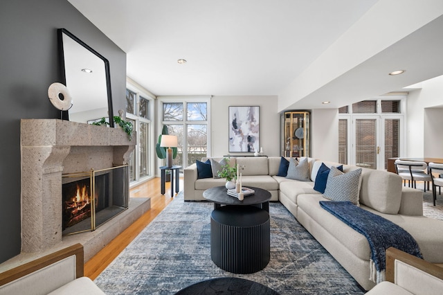 living room featuring a tile fireplace, floor to ceiling windows, and hardwood / wood-style floors