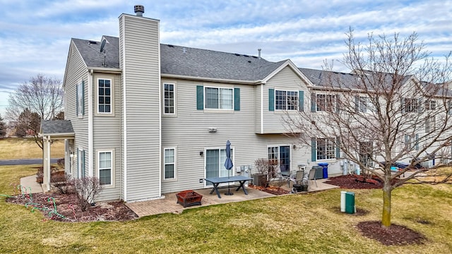 rear view of property featuring a patio area, a lawn, and a fire pit