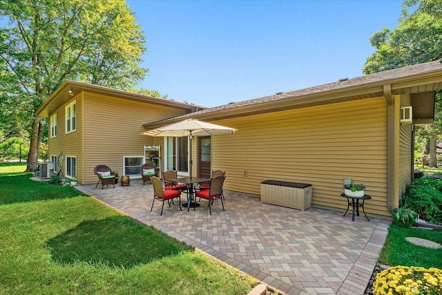 rear view of property with central AC unit, a patio area, and a lawn