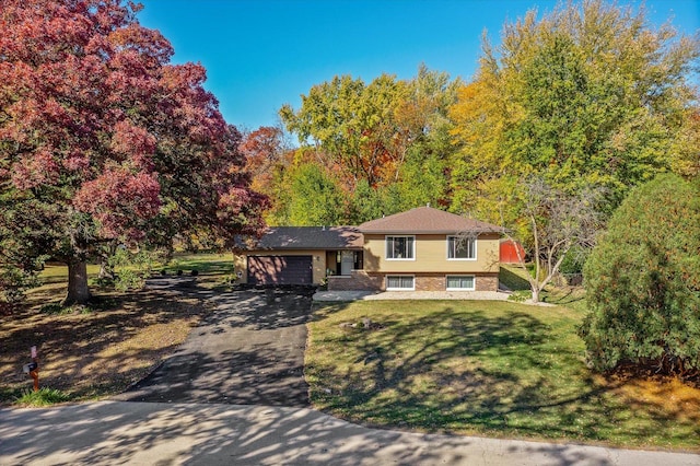 split level home with a garage and a front lawn