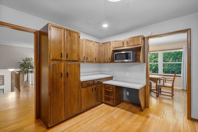 kitchen with light hardwood / wood-style floors and built in desk