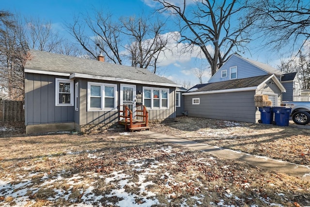 snow covered rear of property with a garage