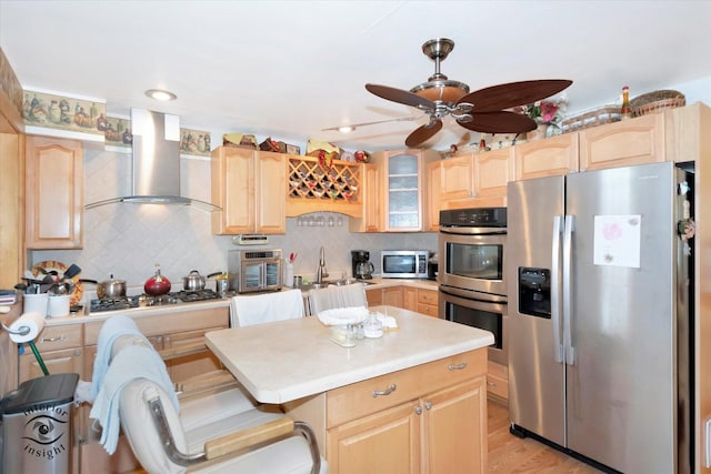 kitchen featuring stainless steel appliances, light brown cabinets, ventilation hood, and backsplash