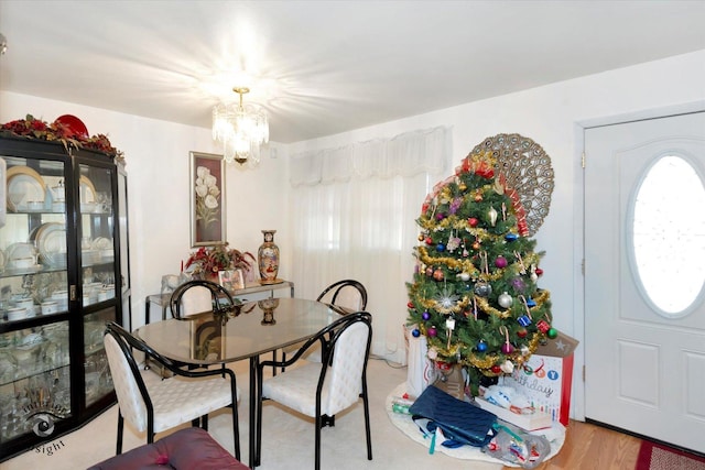 dining space with light hardwood / wood-style floors and a notable chandelier