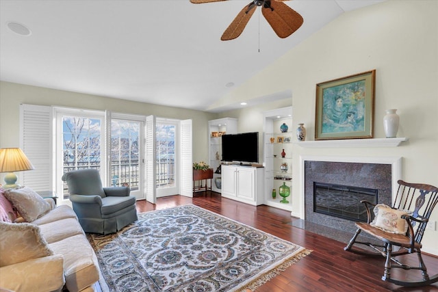 living room with lofted ceiling, dark hardwood / wood-style floors, ceiling fan, and built in shelves